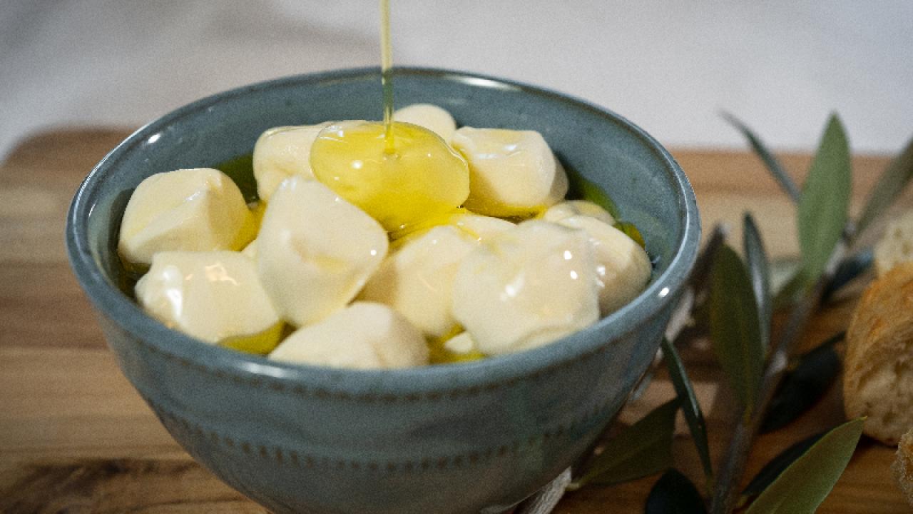 Olive oil poured over cheese on a table