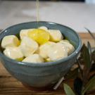 Olive oil poured over cheese on a table